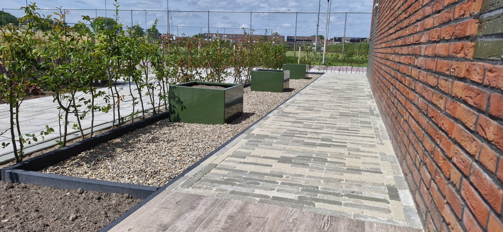 Vakkundige bestrating met waaltjes, plantenbakken en grindvakken